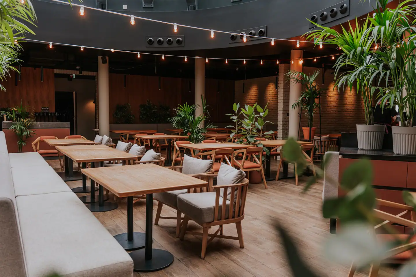 Jasne, pełne zieleni wnętrze restauracji